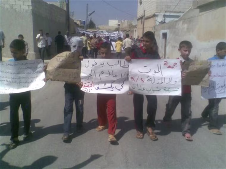 In this citizen journalism image made on a mobile phone and provided by Shaam News Network, anti government protesters hold Arabic placards reading:\"The Friday of Death Rather Than Humiliation\", center right, and \"We want the free media to enter and reveal the truth\", center left,during a demonstration against the Syrian regime, at Andan village, in Aleppo province, Syria, on Friday Sept. 2, 2011. Syria faced international calls for tougher sanctions as anti-government protesters vowed Friday they will choose death over humiliation at the hands of the regime. (AP Photo/Shaam News Network) EDITORIAL USE ONLY, NO SALES, THE ASSOCIATED PRESS IS UNABLE TO INDEPENDENTLY VERIFY THE AUTHENTICITY, CONTENT, LOCATION OR DATE OF THIS HANDOUT PHOTO